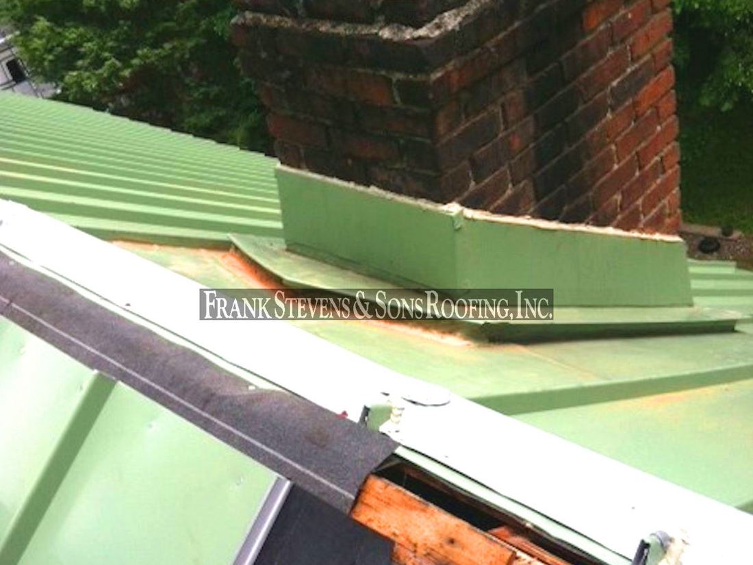 Standing seam metal roof flashing at a chimney