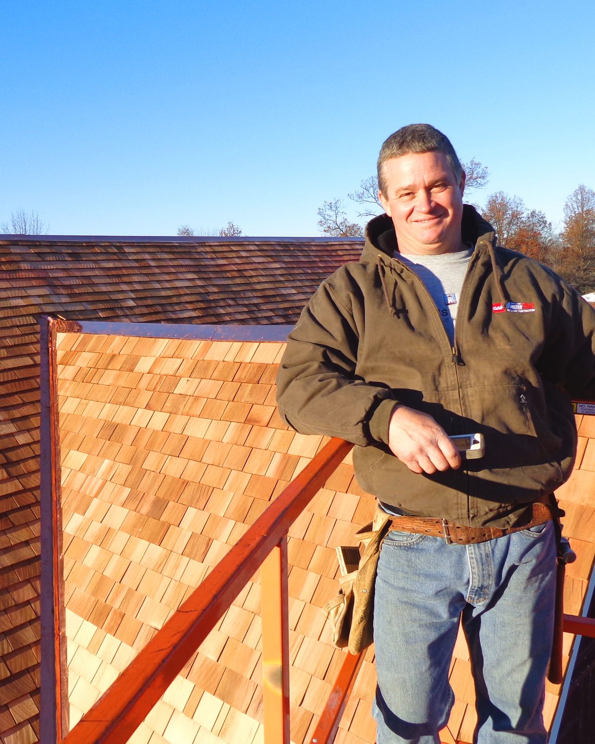 Frank Stevens and Sons roofer in front of a completed cedar shake roof